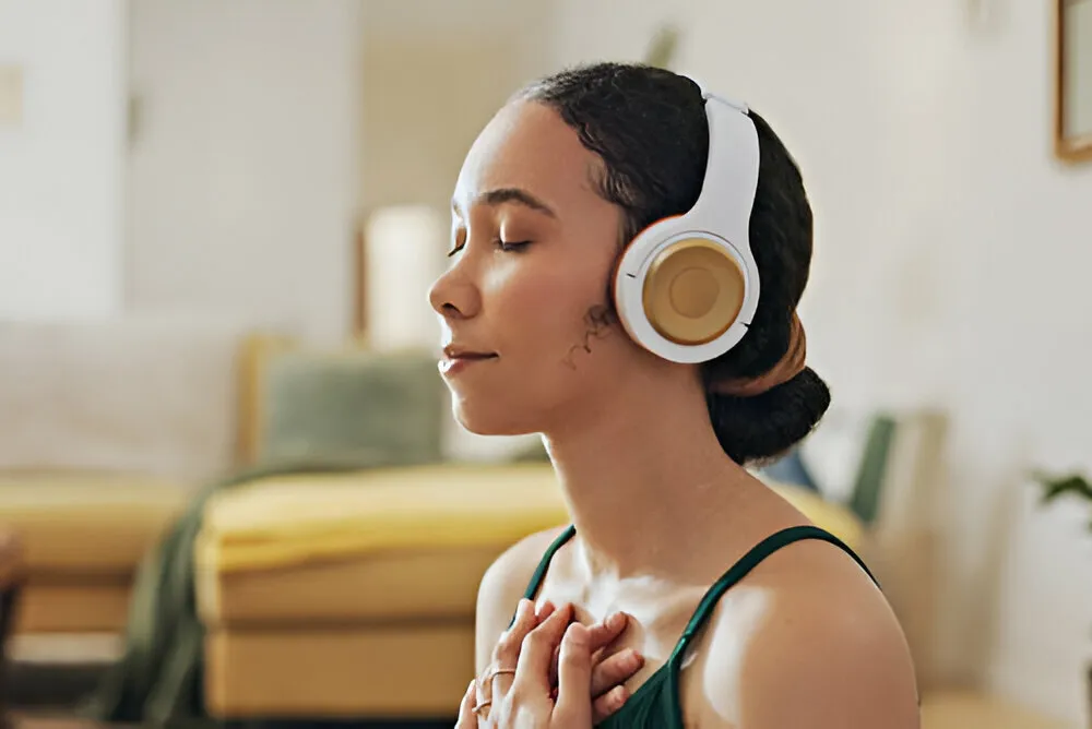 Woman listening to a guided hypnosis session on headphones to quit smoking